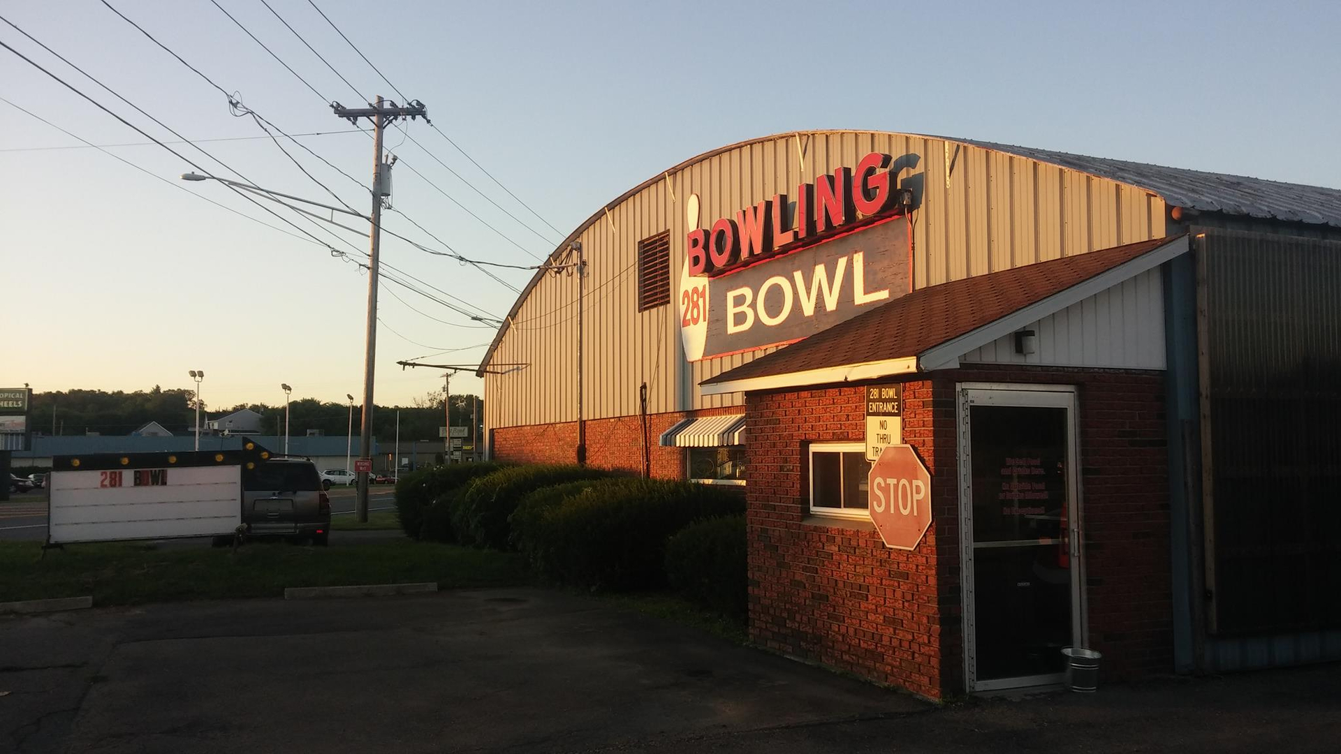 281 Bowl building and entrance at sunset with the neon sign lit