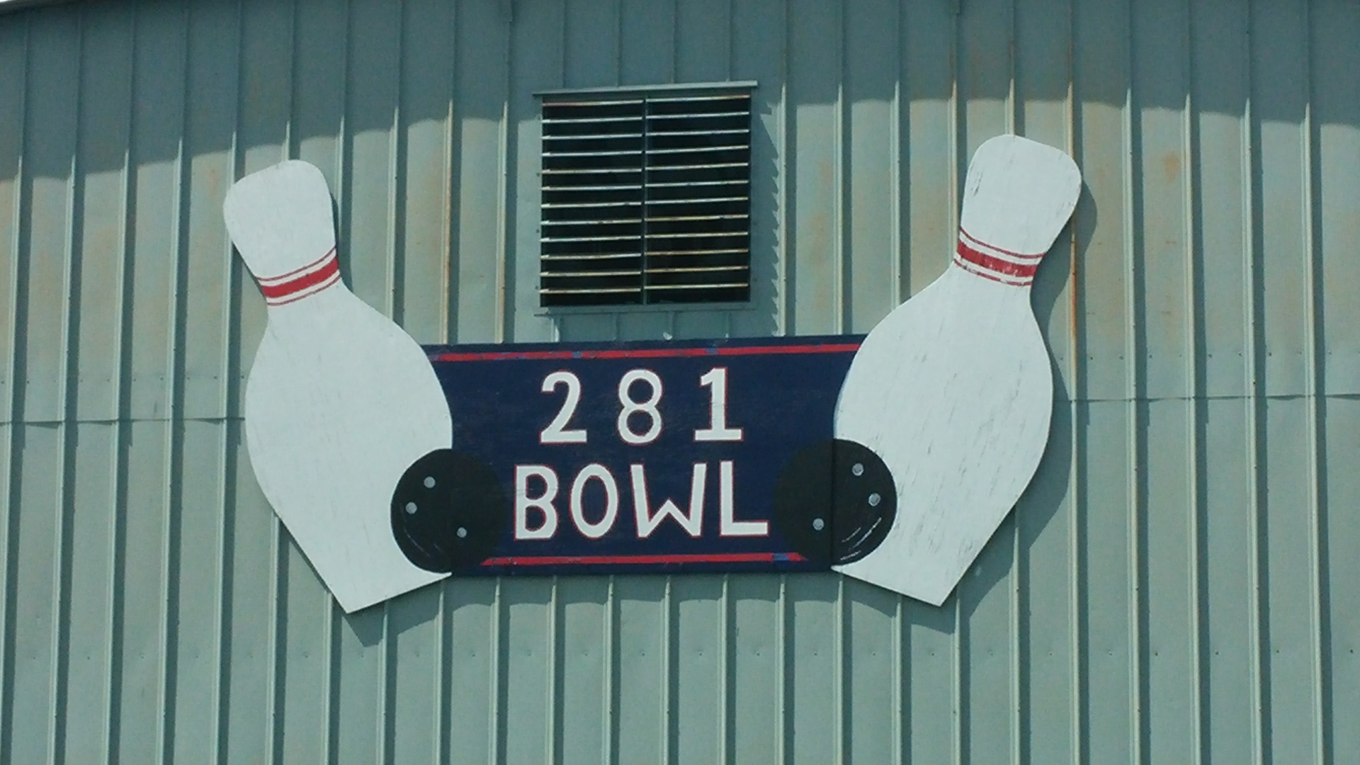 The hand-painted 281 Bowl bowling-pin sign at golden hour
